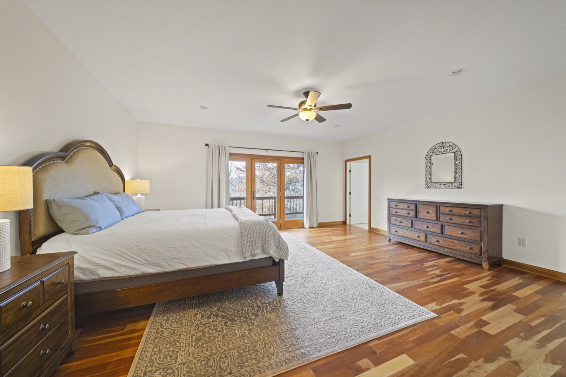 Primary bedroom suite with king bed and balcony access at Long Lake Lodge