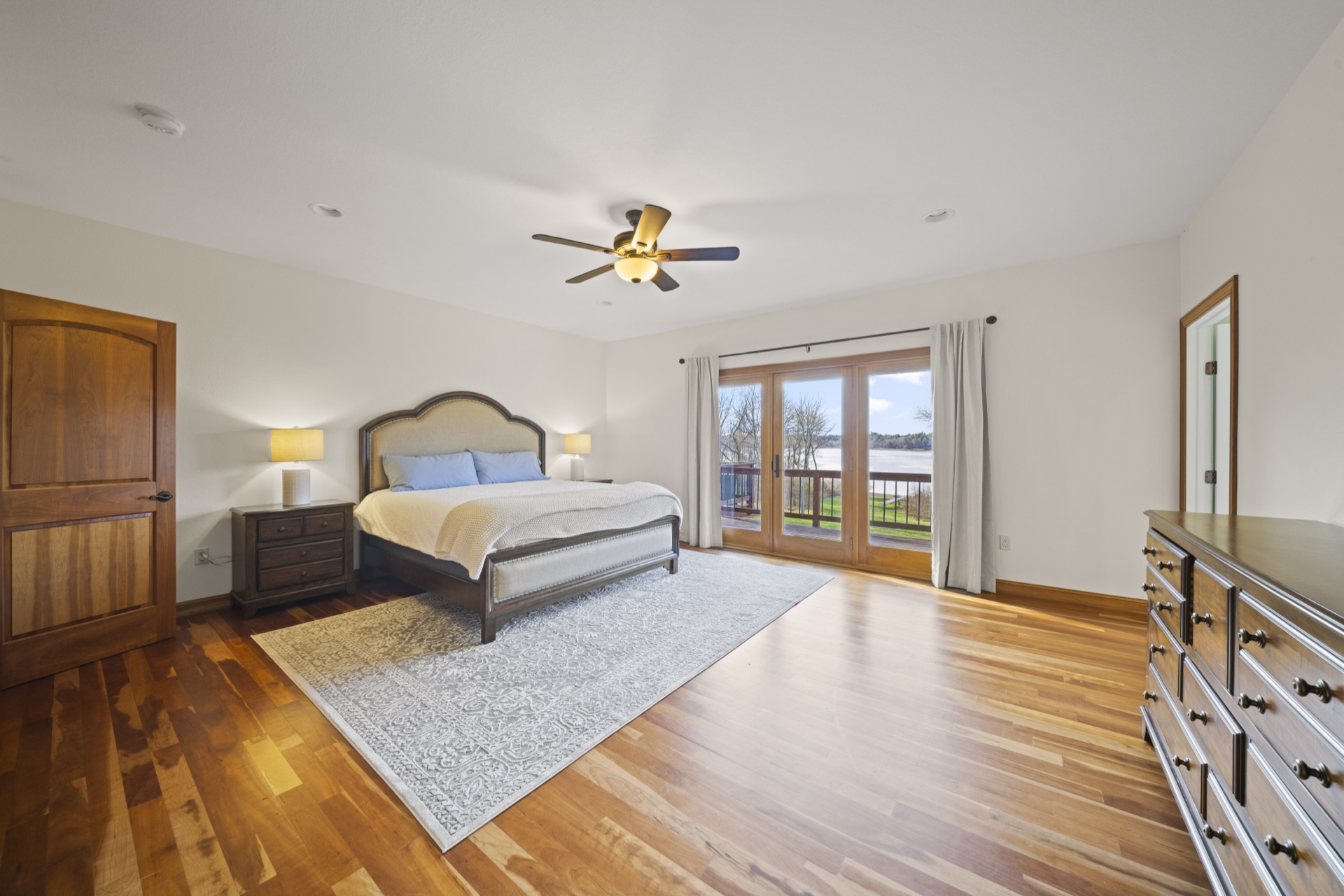 Primary bedroom with private balcony access and lake views